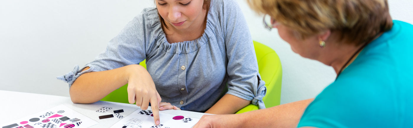 "Young woman completing an ADHD cognitive assessment with a clinician at ZenWaves Clinic, Sydney. They are seated at a table with test cards, focusing on attention and neuropsychological testing."